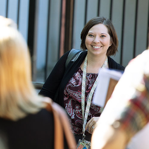 A student in PsyD program smiling while walking on campus
