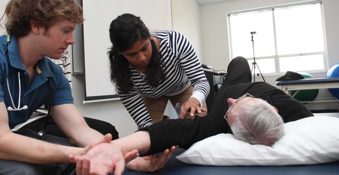 Two PT students work with an elderly patient