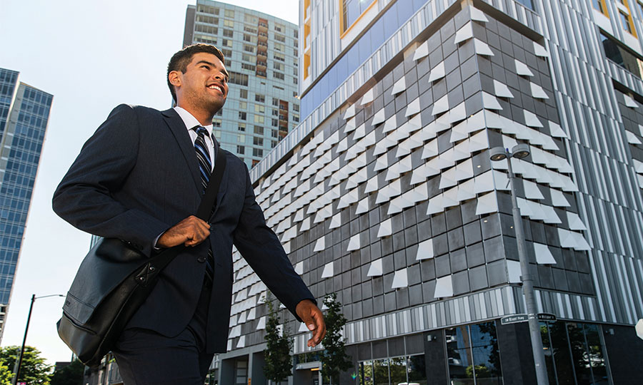 Person in a suit walking outside an office building