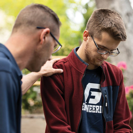 Professor praying over his student