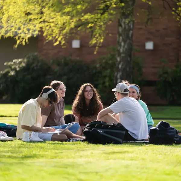 Students sit on the campus quad and talk