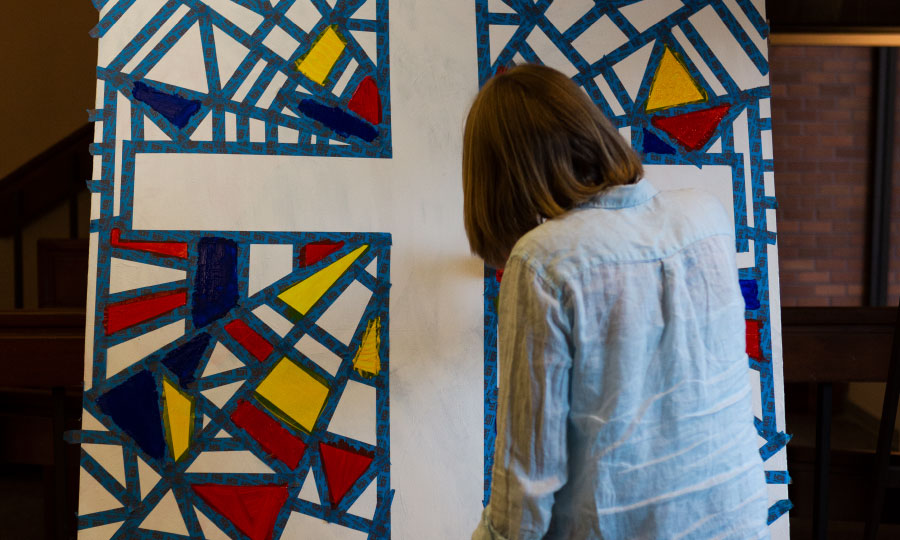 student painting a cross