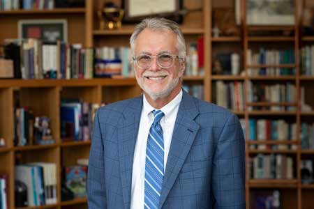 President Robin Baker standing in his office