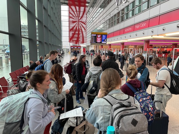 Students stand in an airport