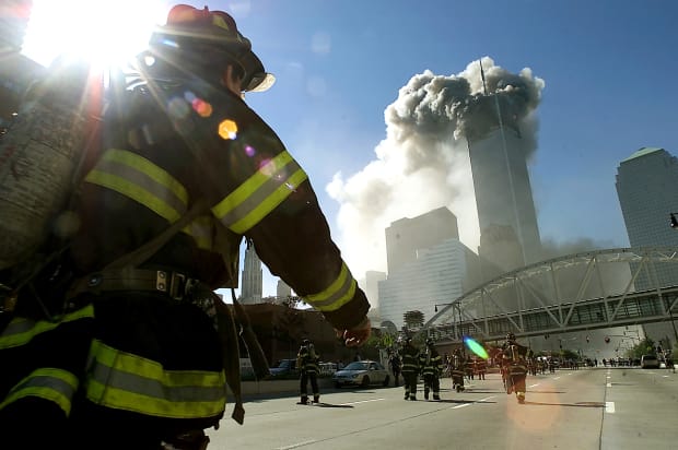 Firefighters walk towards one of the towers at the World Trade Center before it collapsed.