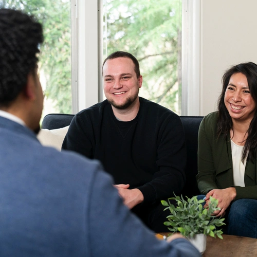 a couple sitting on a couch taking to a counselor