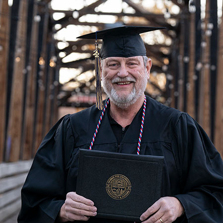 Happy graduate holding his diploma