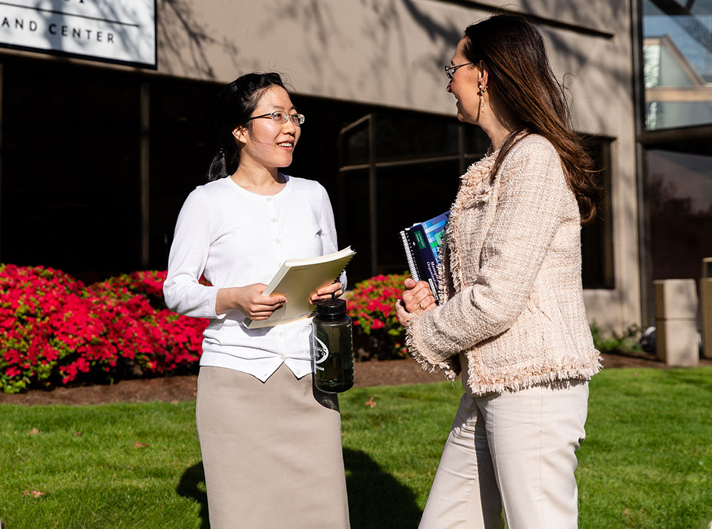 two professional women speak outside