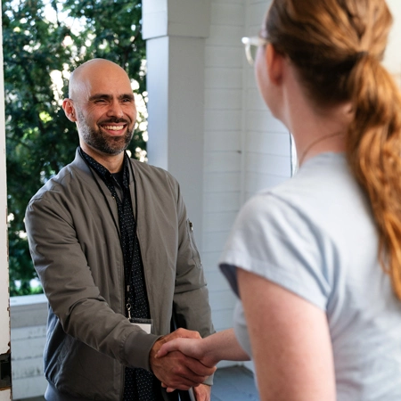 social worker greeting a client at their door