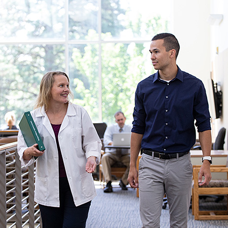 Two professionals in healthcare industry having a conversation while walking