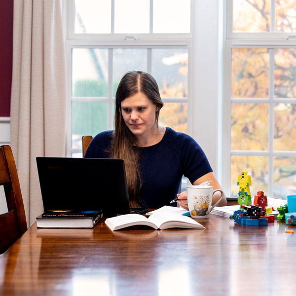 Woman works on laptop at dinning table