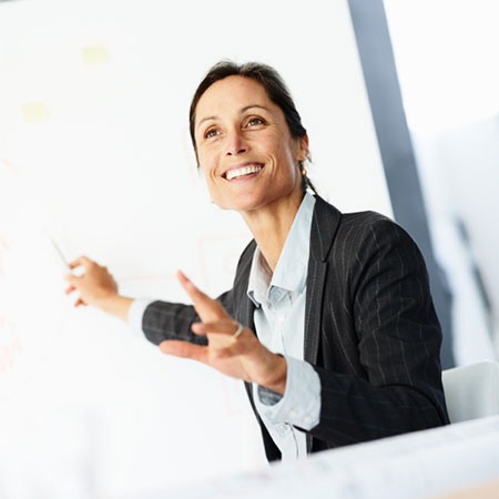 A professional woman presenting on a whiteboard