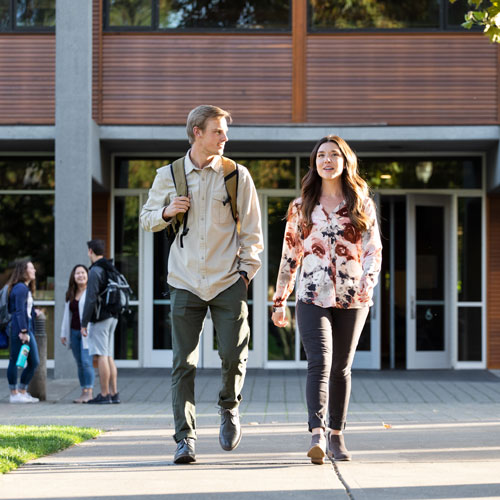 A student walks with a community mentor