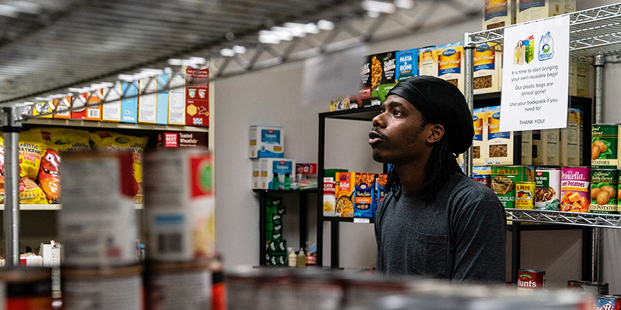 Student taking food off the shelves of the pantry