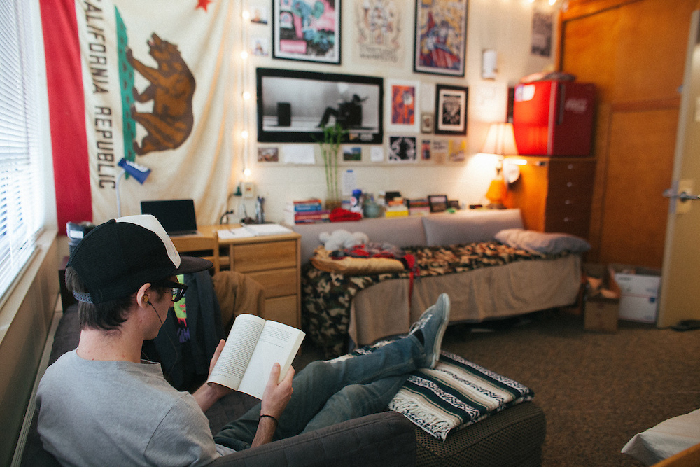 A student reads a book in his dorm room