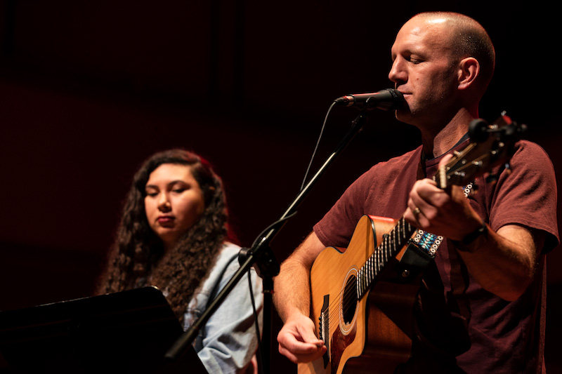 A campus pastor leads worship during chapel