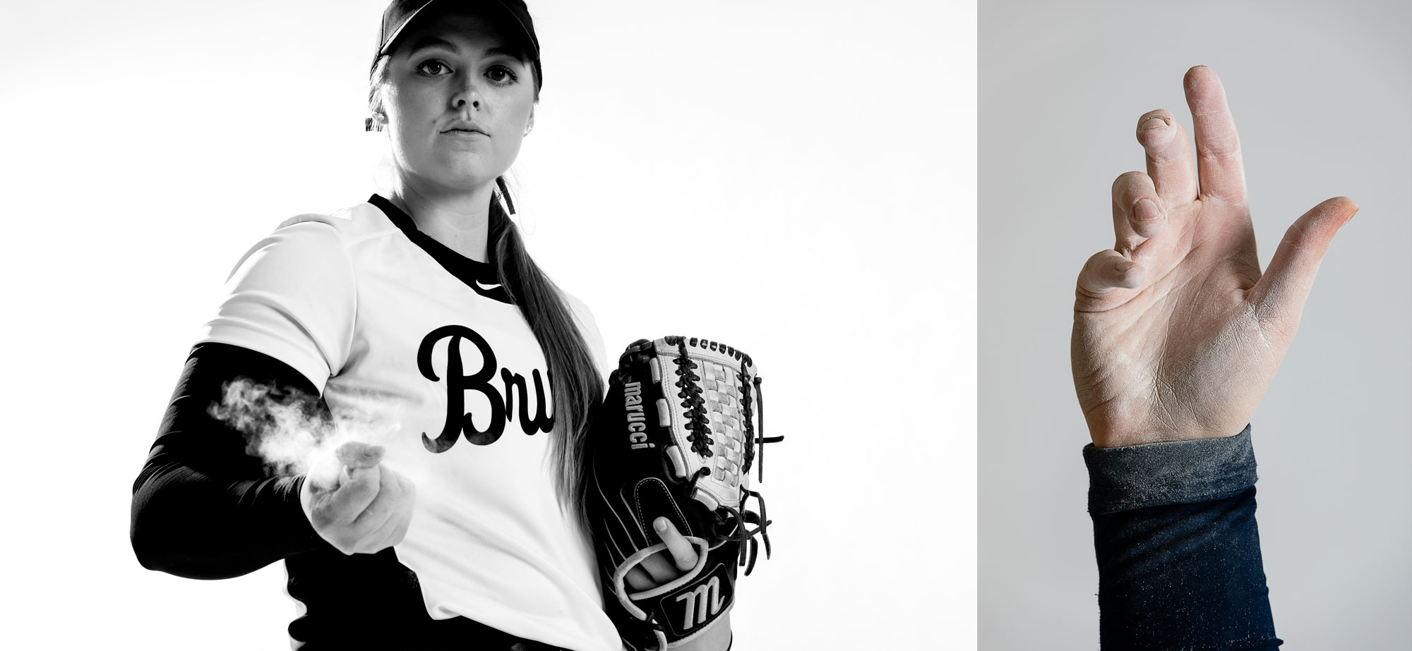 A softball player holds chalk dust in her hand