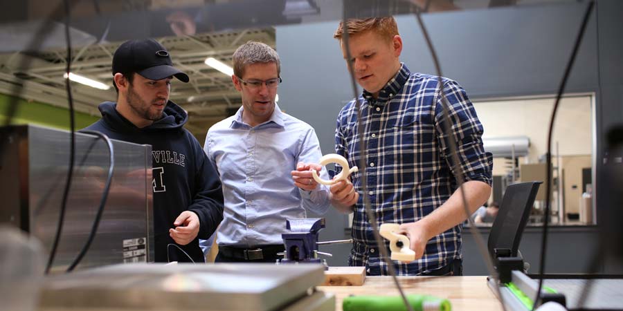 Engineering students and a professor working in the maker hub