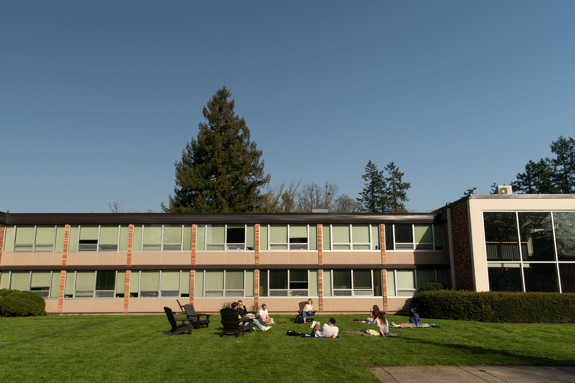 Students sit on the lawn outside Pennington Hall