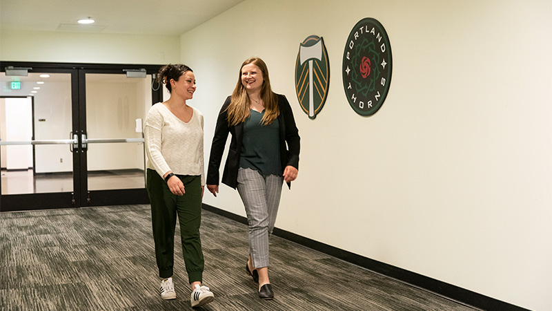 Jensyn walking through a hall with Portland Timbers and Thorns logos on it