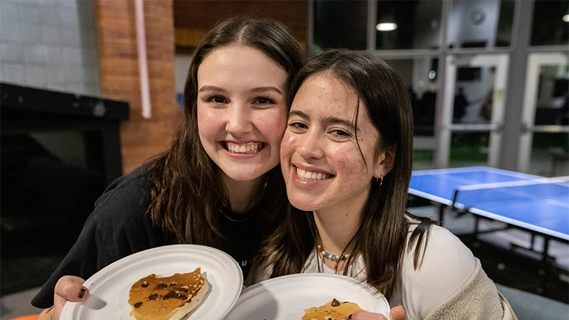 Two friends with plates of pancakes