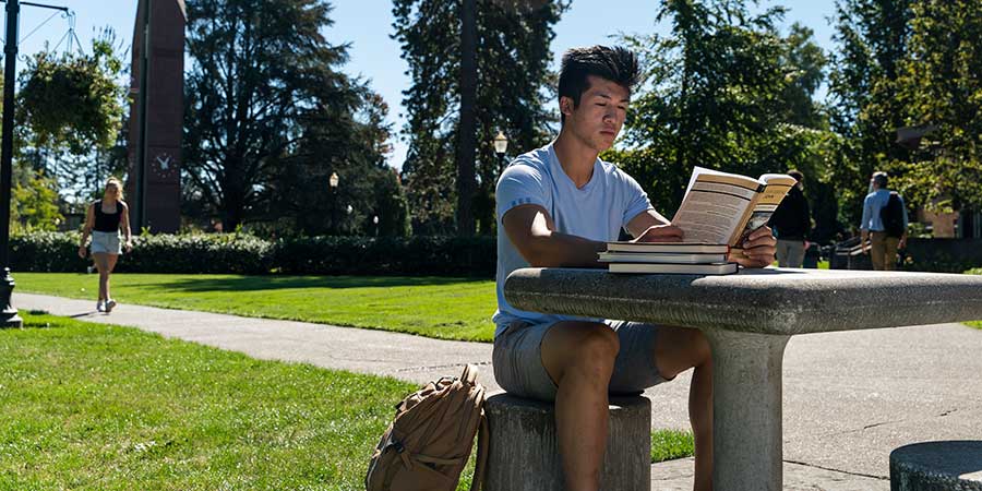 student reading in the quad