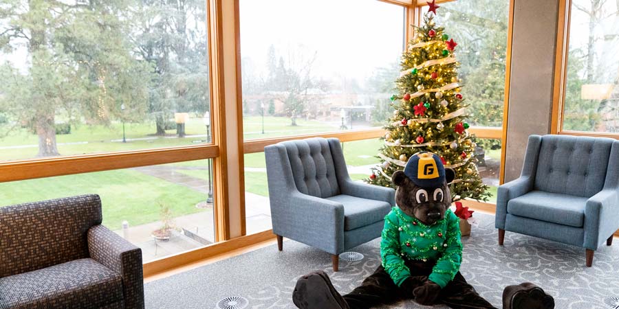 Pennington sitting next to a Christmas tree