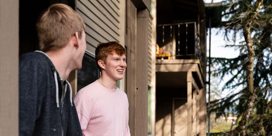 Two students in an apartment balcony