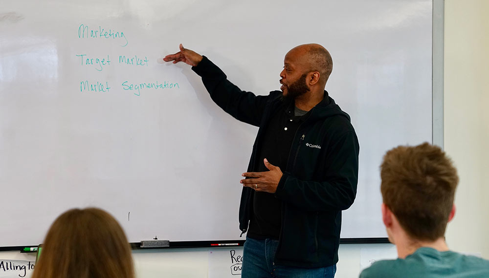 James Redmond pointing at a whiteboard