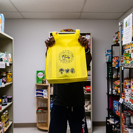 student holding up bag of food