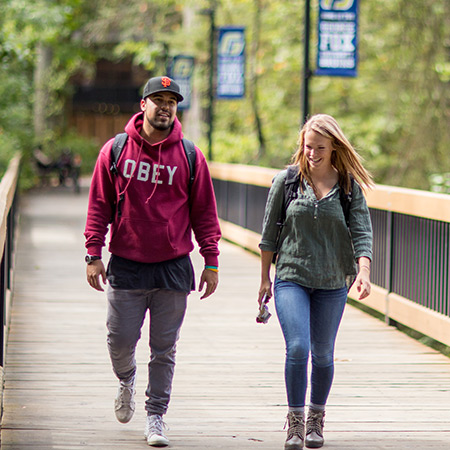 two students walking on a bridge