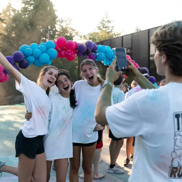 A student takes a photo of his friends at the color run
