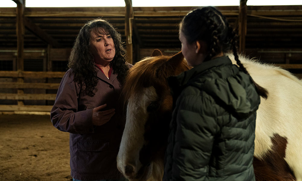 Mindy Sutton with horse and younger client