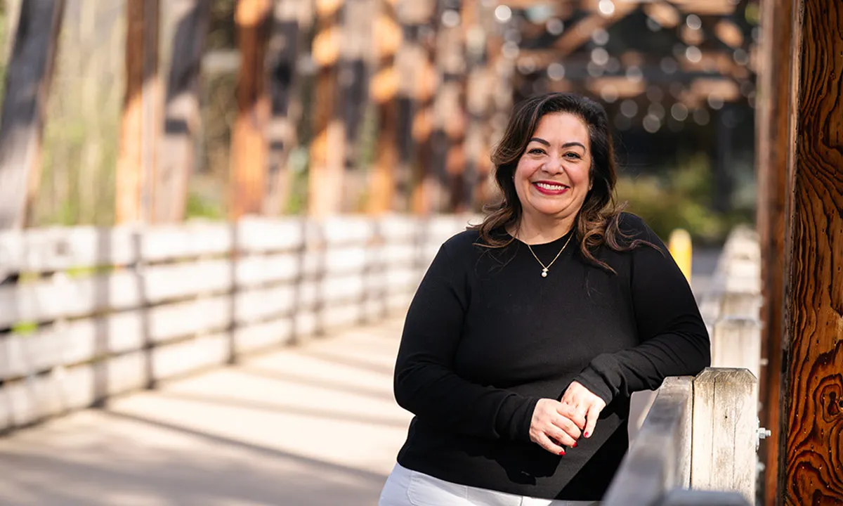 PsyD Graduate Grace Witt stands on a bridge on campus
