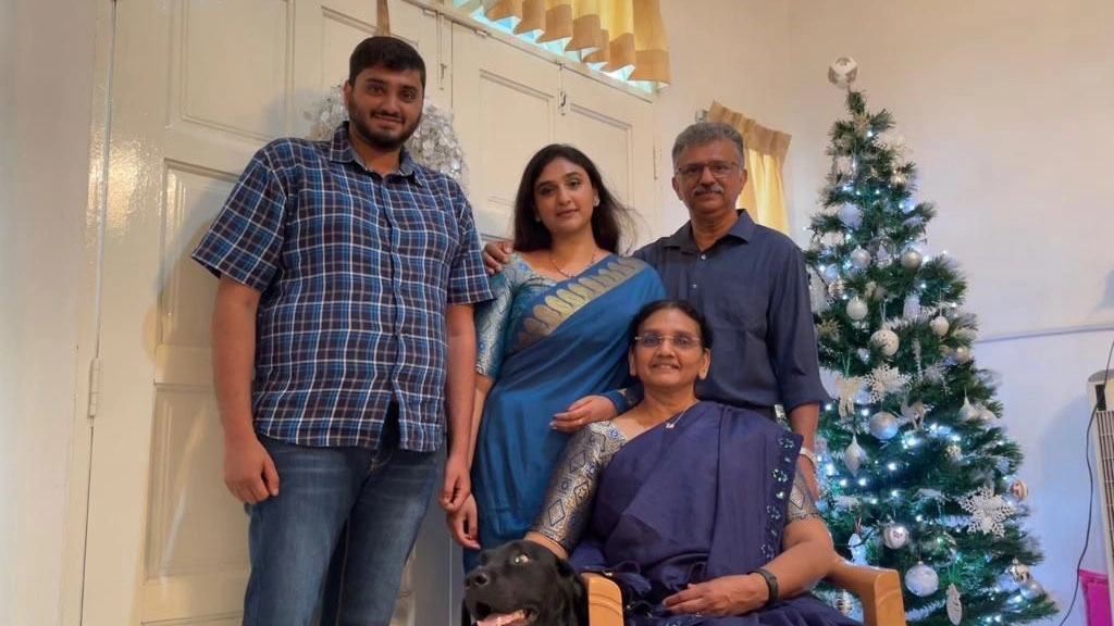 Rachel smiling with her family inside of a home