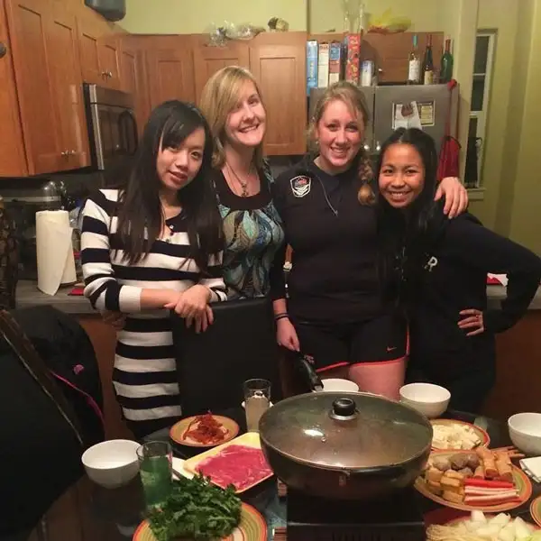 Allison standing with friends behind a dinner table