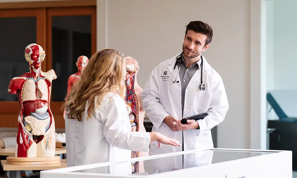 Stan talks with another PA in a lab with anatomical models