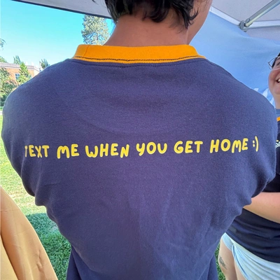 Back of a commuter life staff member's shirt, saying "text me when you get home"