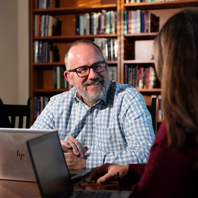 Troy Fisher doing computer work with a student