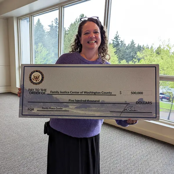 Lisa holds a massive check for the Family Justice Center of Washington