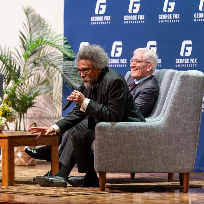 Cornel West and Robert P. George talk and laugh on stage