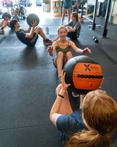 Two kids pass a weighted medicine ball back and forth