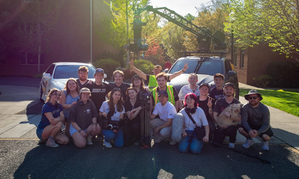 group picture of the cinematic arts team in front of a drift car
