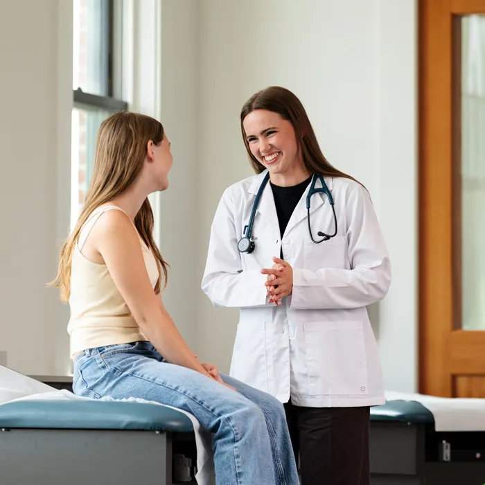 An osteopathic MD chats with a young female patient