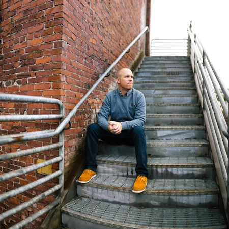 Ben sitting on brick steps, looking to the right