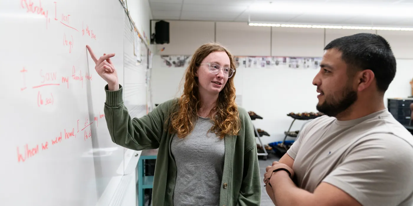Emmy King gestures to the whiteboard in the classroom