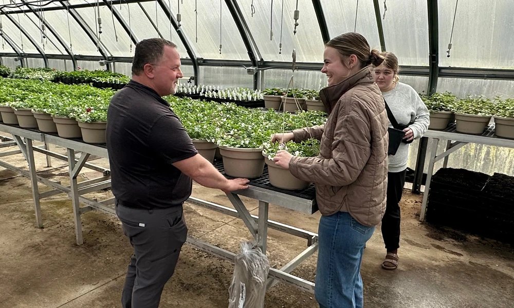 Martz talking to students in a greenhouse