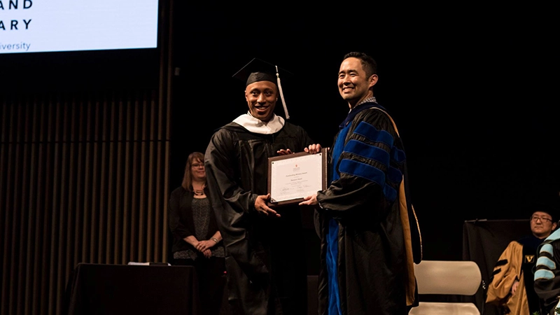 Mario receiving his diploma at Portland Seminary graduation