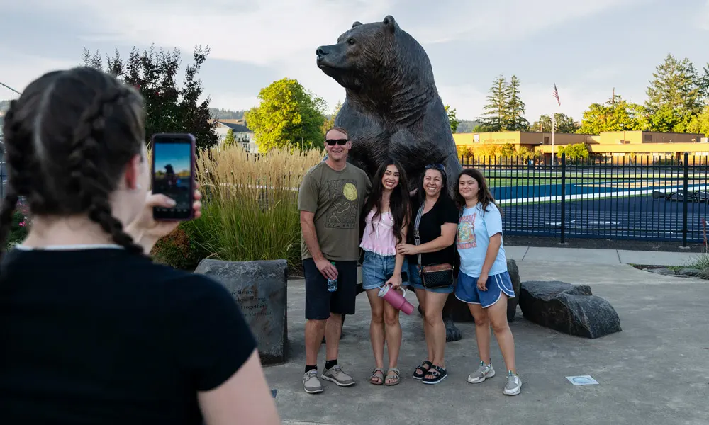 A student poses for a photo with her family during welcome weekend 