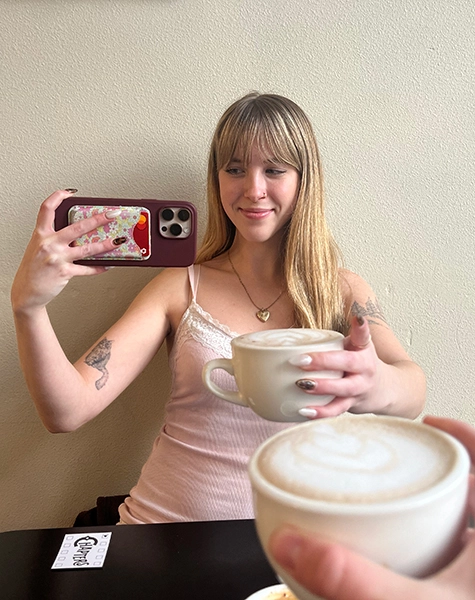 Grace smiling and holding a coffee